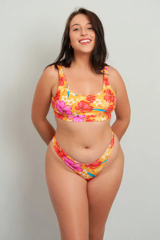 A model wearing a multicolor floral crop top and matching bottoms.