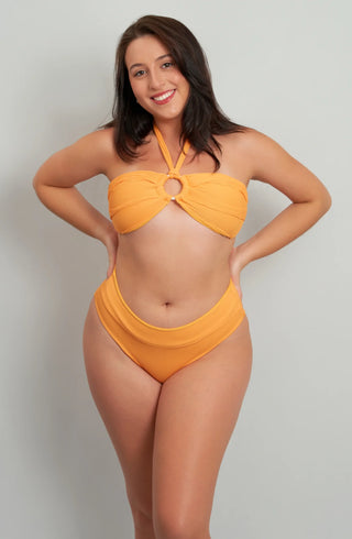 Smiling woman modeling full front view of a tangerine orange ribbed high-waisted bikini set with a bandeau halter top and gold ring detail