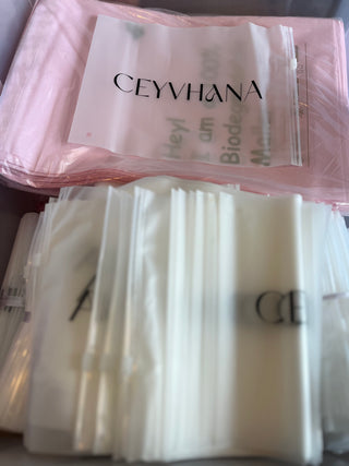 Packaged items with visible branding on a pink background